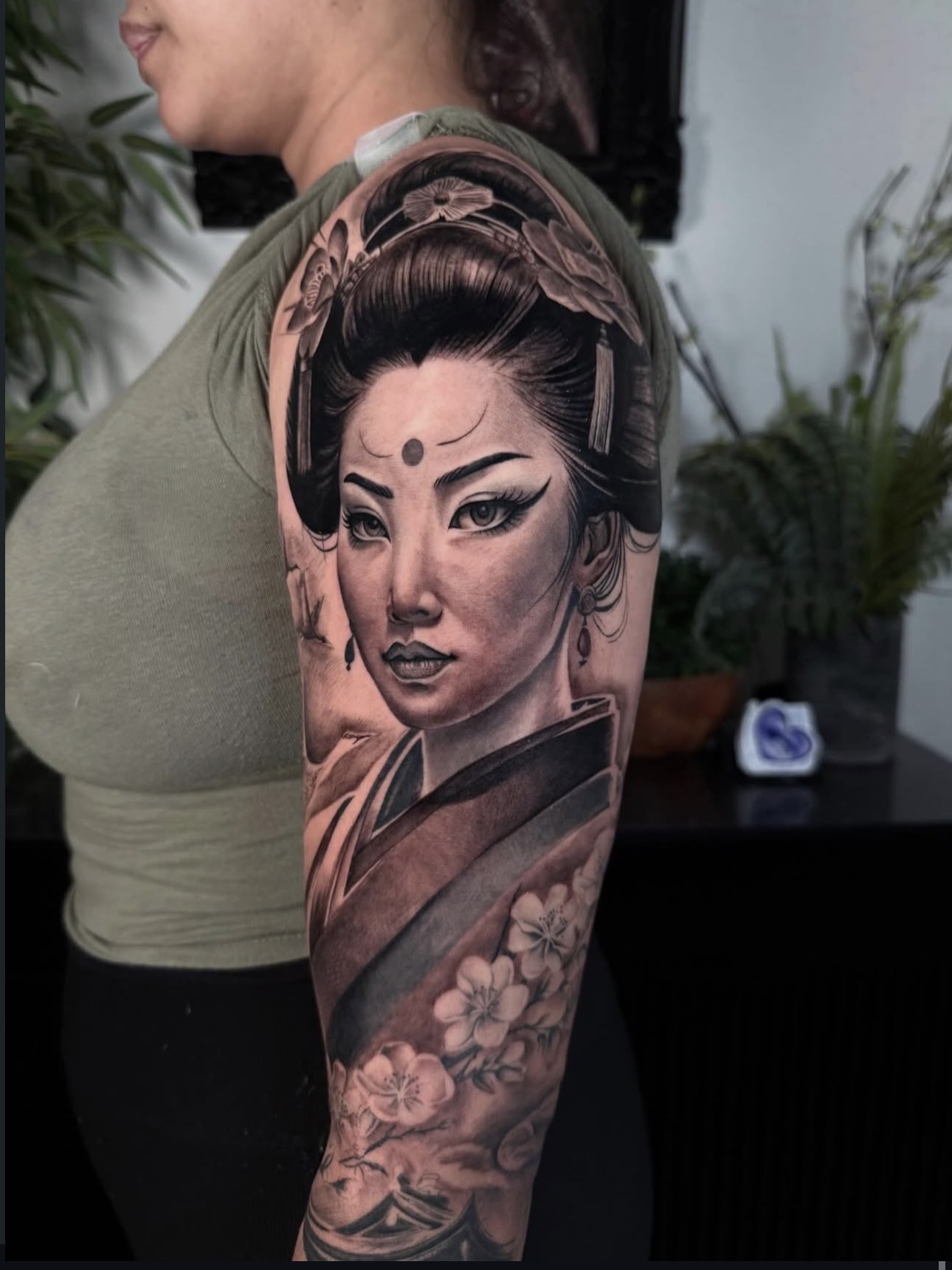 Black and grey geisha portrait half sleeve tattoo with cherry blossoms by Sandra