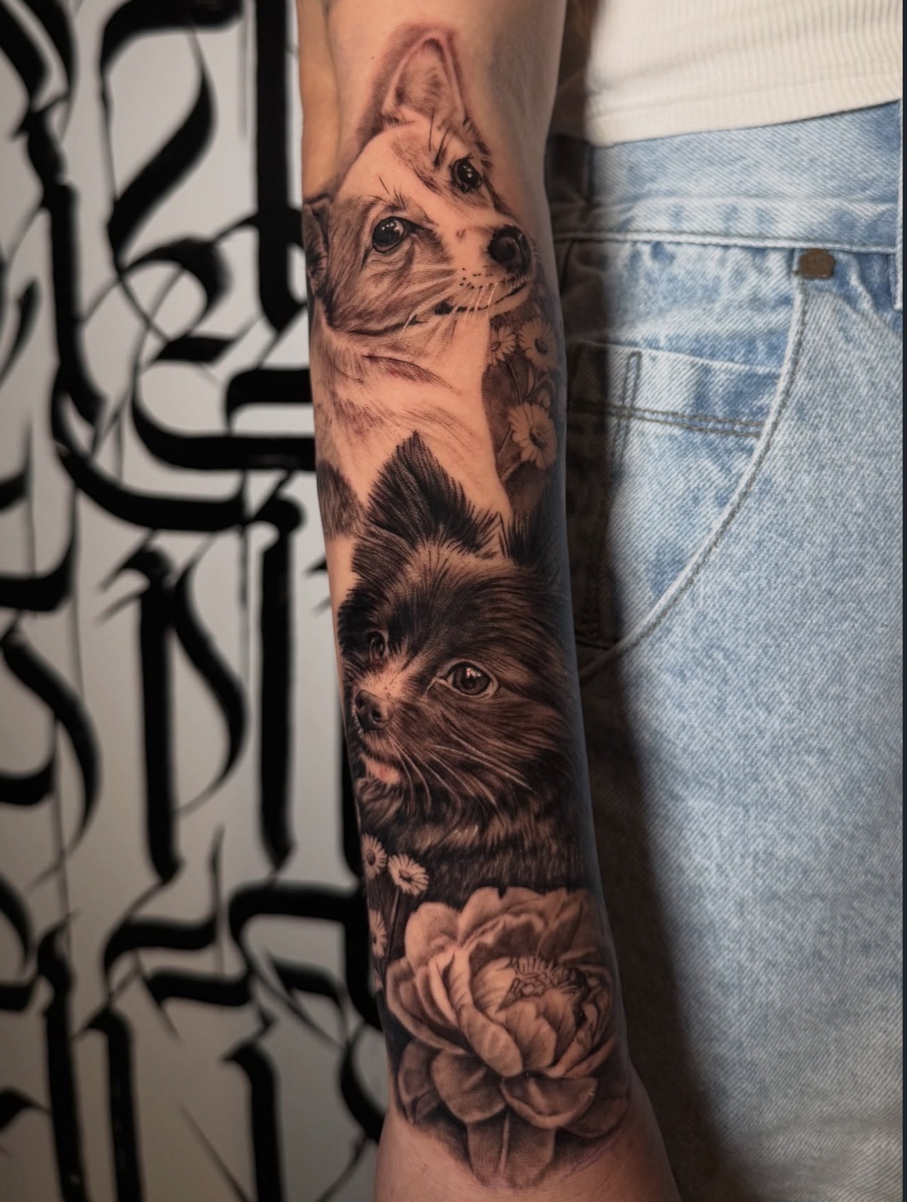 Black and grey dog portraits and floral forearm tattoo by Sandra